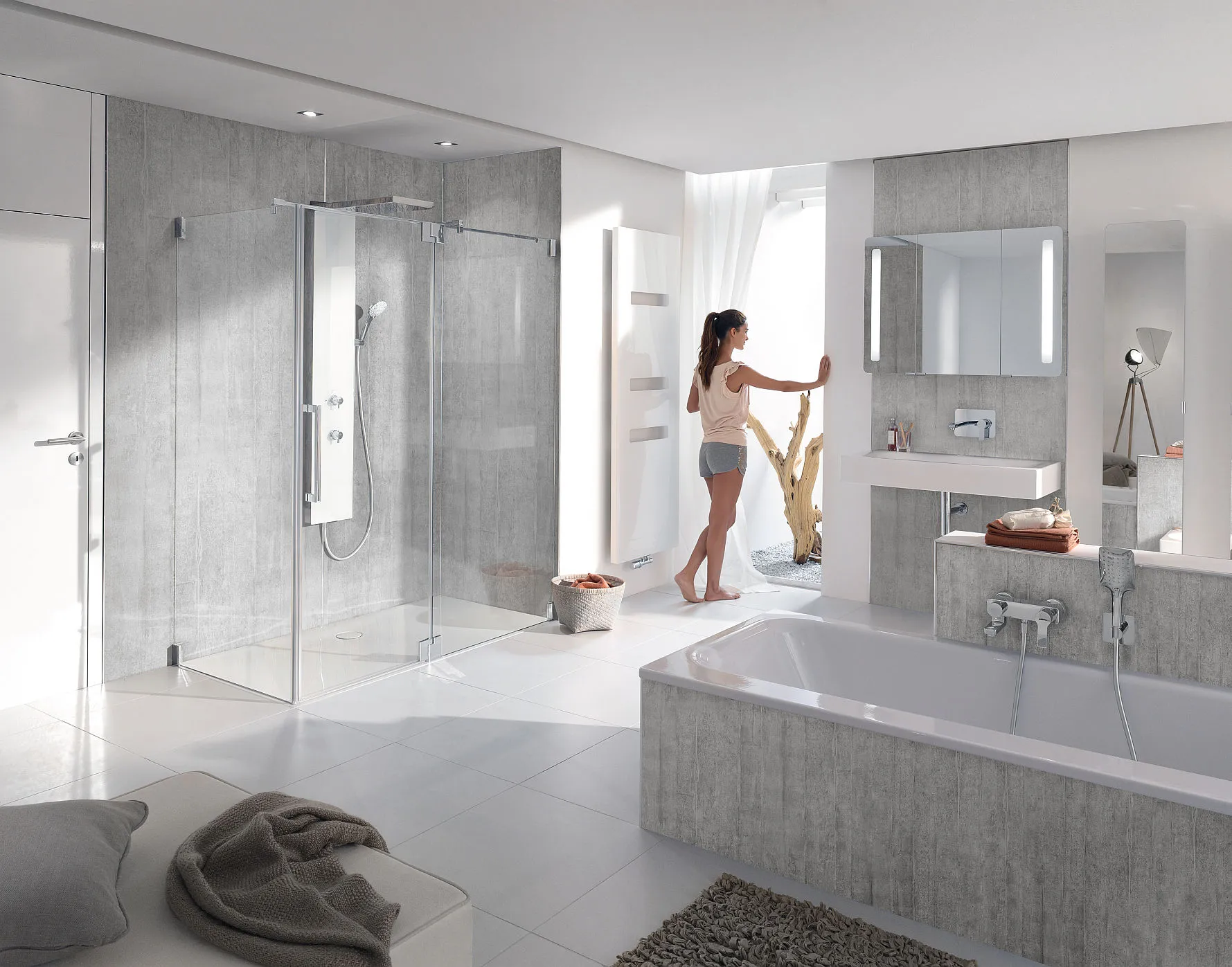 Frau im Badezimmer mit Wandverkleidung in Sichtbetonoptik.