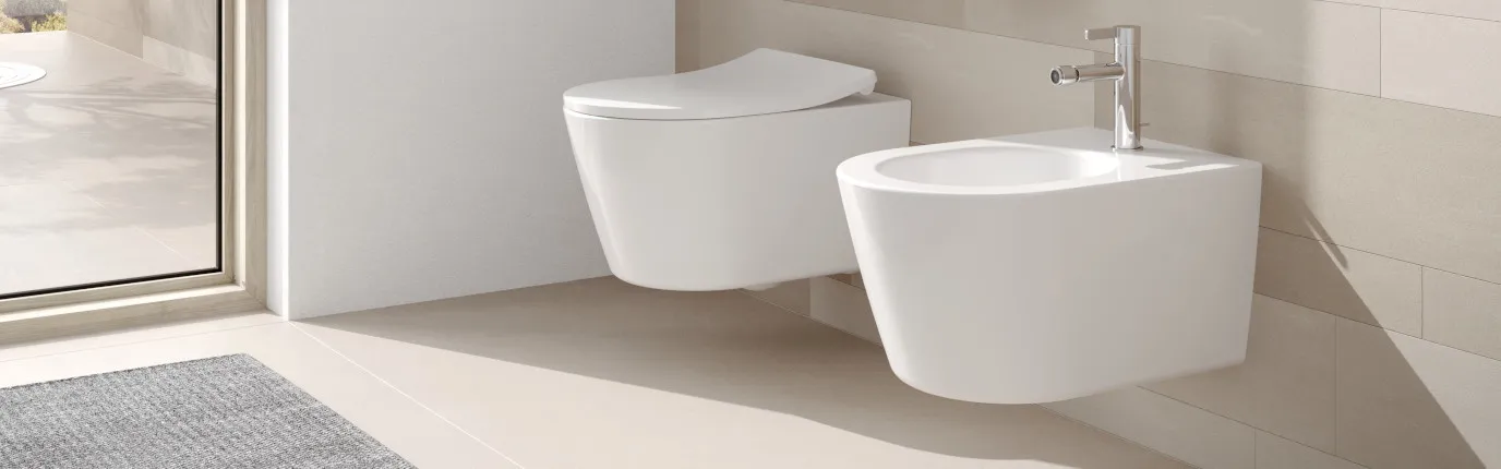 Ein modernes Badezimmer mit einer hängenden Toilette und einem daneben platzierten wandmontierten Bidet.