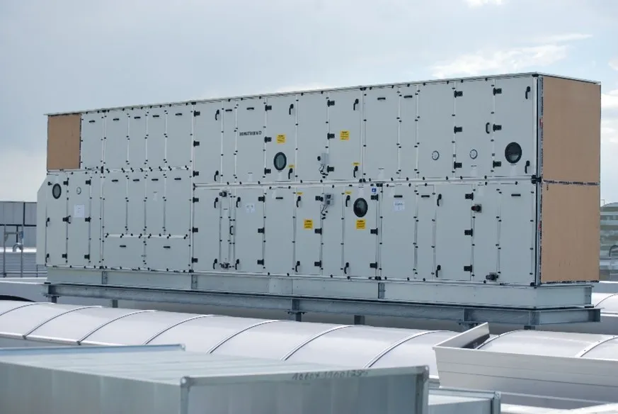 Eine große, zweigeschossige Lüftungszentrale steht auf dem Flachdach eines Industrie- oder Gewerbegebäudes.