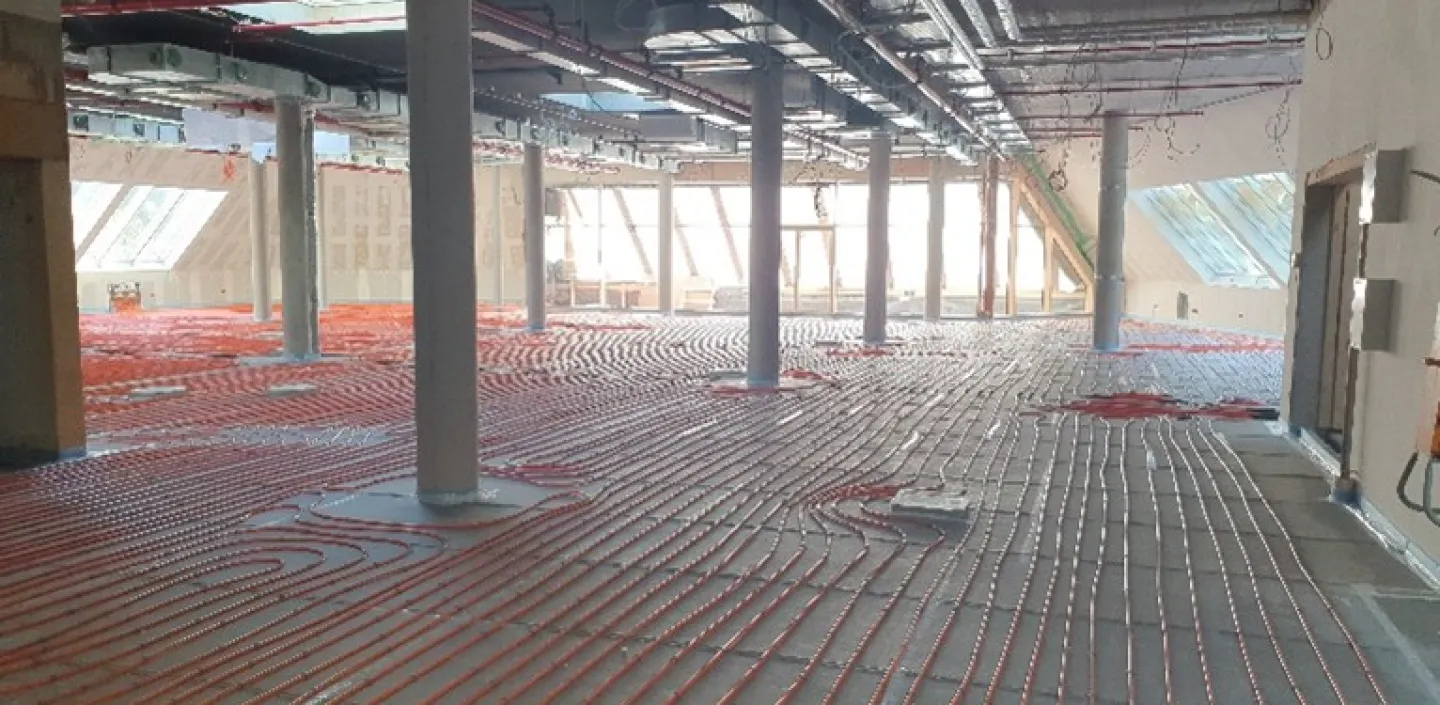 Moderne Flächenheizung mit Betonkernaktivierung in einem Gewerbebau – effiziente Heiz- und Kühllösung mit verlegten Rohrleitungen im Rohbau.