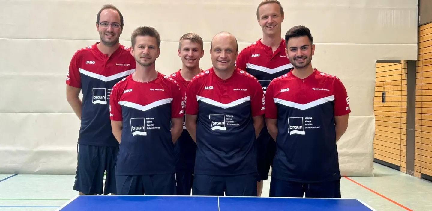 Sechs Tischtennisspieler stehen mit Sponsoring-Trikots von Braun in zwei Dreierreihen aufgereiht hinter der Tischtennisplatte.
