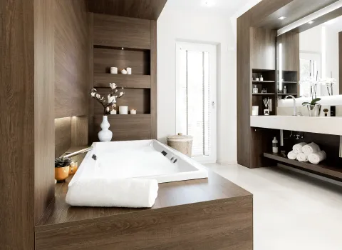 Ein Badezimmer mit Badewanne und Waschtisch mit hellem Boden und dunkler Holzverkleidung.