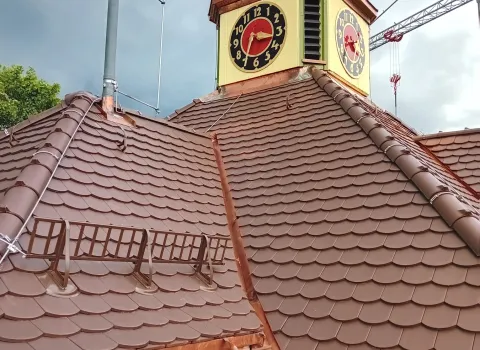 Dachaufnahme eines Gebäudes mit brauner Schuppeneindeckung und sauber ausgeführten Kupferanschlüssen.