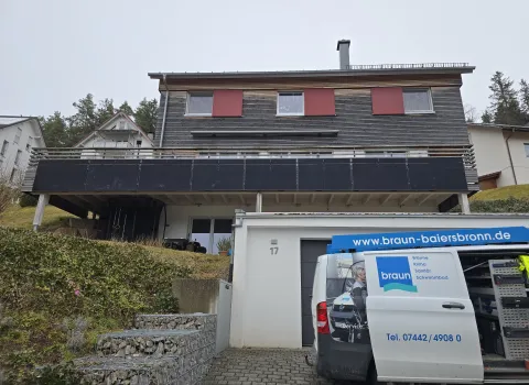 Wohnhaus mit Balkon-Solaranlage, davor ein Servicefahrzeug der Gottfried Braun GmbH mit Firmenaufdruck und geöffneter Werkzeugausstattung.