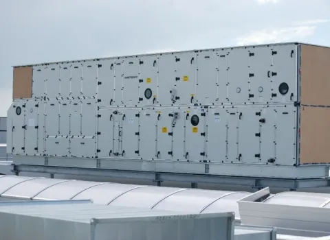 Eine große, zweigeschossige Lüftungszentrale steht auf dem Flachdach eines Industrie- oder Gewerbegebäudes.