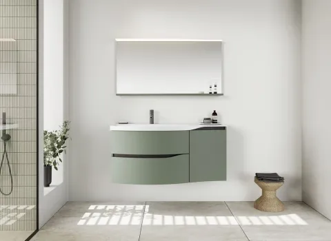 Ein modernes, ruhiges Badezimmer mit minimalistischer Einrichtung zeigt ein grün-mattes, geschwungenes Waschtischmöbel der Serie Sinea 3.0 von burgbad mit integriertem Waschbecken.