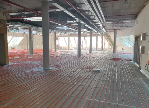 Moderne Flächenheizung mit Betonkernaktivierung in einem Gewerbebau – effiziente Heiz- und Kühllösung mit verlegten Rohrleitungen im Rohbau.