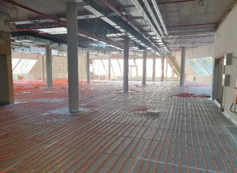 Moderne Flächenheizung mit Betonkernaktivierung in einem Gewerbebau – effiziente Heiz- und Kühllösung mit verlegten Rohrleitungen im Rohbau.