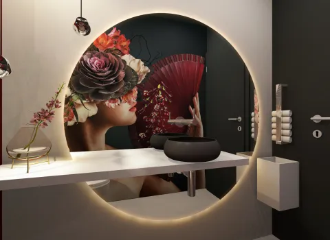Modernes Designerbad mit runder LED-Spiegelbeleuchtung, Aufsatzwaschbecken und kunstvoller Wandgestaltung mit Frauenmotiv.