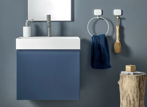 Kompaktes Badezimmer von Stocco mit blauem Unterschrank, weißem Aufsatzwaschbecken und minimalistischen Wandaccessoires.