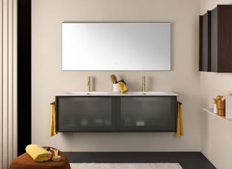 Farblich harmonisches Badezimmer von Stocco mit Doppelwaschtisch, matter Glasfront, goldenen Armaturen und wohnlichen Details.