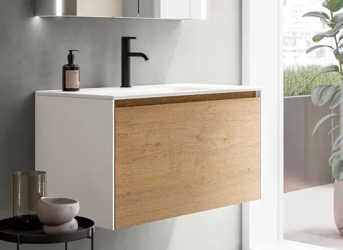 Freischwebender Waschtisch mit heller Holzfront, weißer Keramikplatte und schwarzer Armatur in modernem Badezimmerdesign von Stocco.