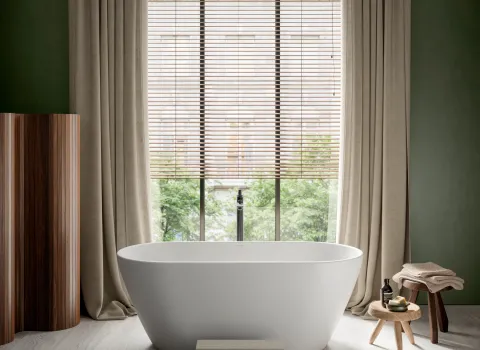 Freistehende Badewanne von Duravit aus der S-Neo-Kollektion vor großem Fenster mit Vorhängen in stilvollem modernen Badezimmer.