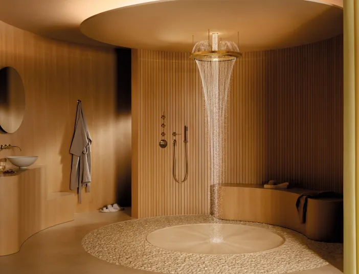 Dusche Aquahalo von Dornbracht in warmen Holztönen mit Wasserskulptur im Mittelpunkt.