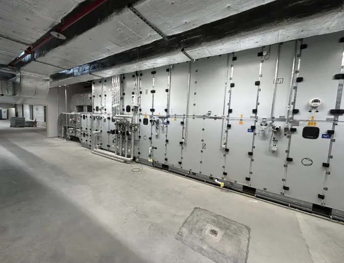 Eine industrielle Klimaanlage in einem Technikraum besteht aus modular aufgebauten Geräteeinheiten mit zahlreichen Zugangs- und Wartungsklappen.