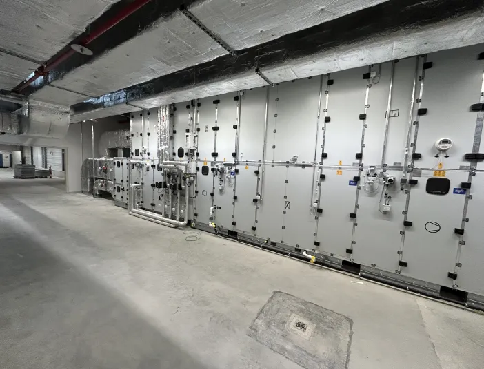 Eine industrielle Klimaanlage in einem Technikraum besteht aus modular aufgebauten Geräteeinheiten mit zahlreichen Zugangs- und Wartungsklappen.